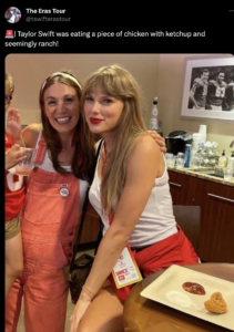 Taylor swift poses with a fan next to a plate with one chicken tender and two condiments: ketchup and ranch