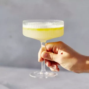 A cocktail glass with a light yellow beverage