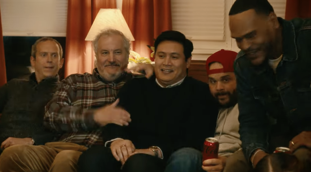 A group of men embrace each other on a couch during a holiday
